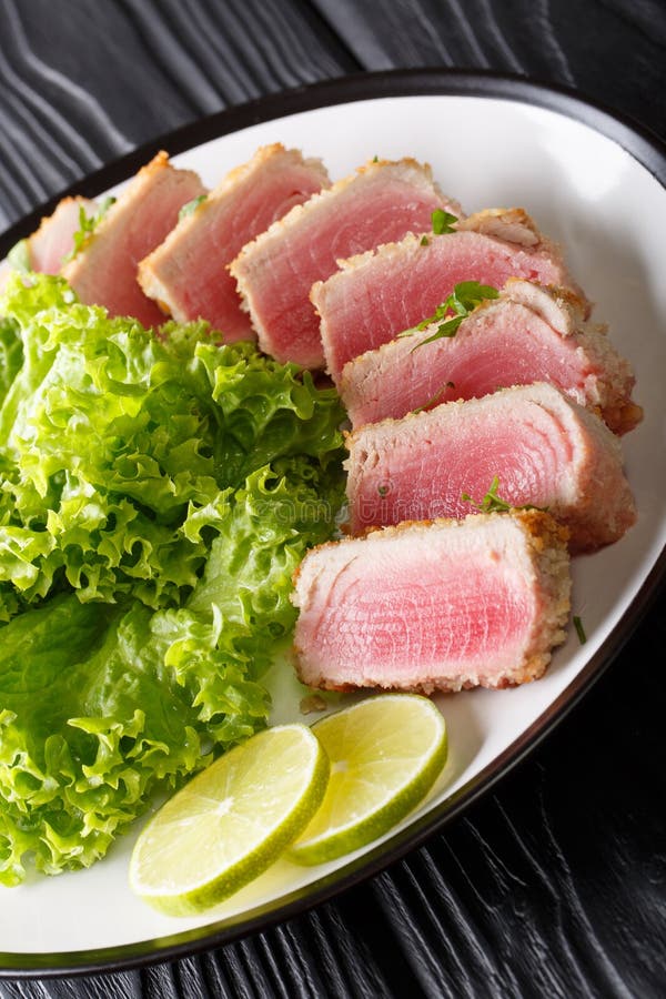 Fried Tuna Steak in Bread Crumbs with Lettuce and Lime Closeup. Stock