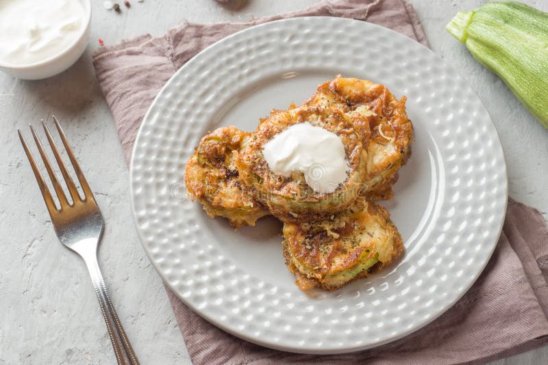 Fried Zucchini Slices in Egg Batter with Garlic on a Plate. Stock Image