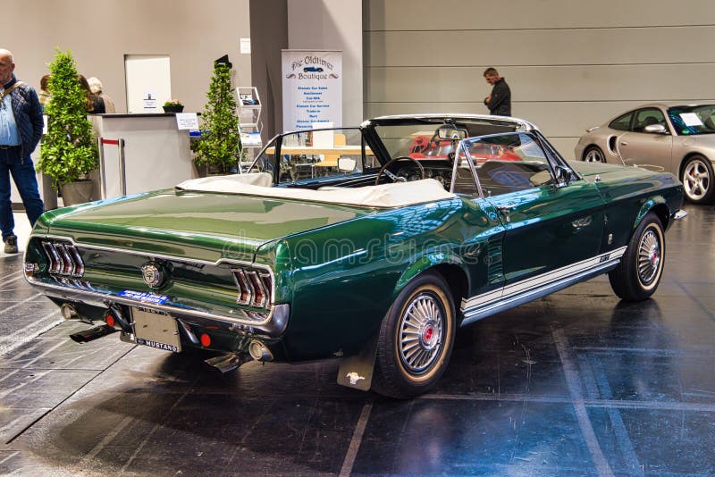 FRIEDRICHSHAFEN - MAJ 2019: mörk smaragd - den gröna FORD MUSTANGET T5 GT SAMLAR cabrioen 1966 på Motorworld klassiker Bodensee p royaltyfria bilder FRIEDRICHSHAFEN - MAJ 2019: mörk smaragd - den gröna FORD MUSTANGET T5 GT SAMLAR cabrioen 1966 på Motorworld klassiker Bodensee p royaltyfria bilder