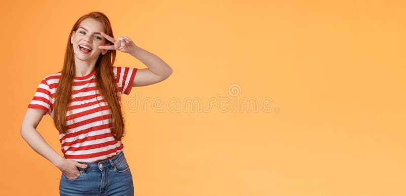 Friendly Attractive Modern Redhead Female College Star Show Peace Victory Sign Near Eye Smiling