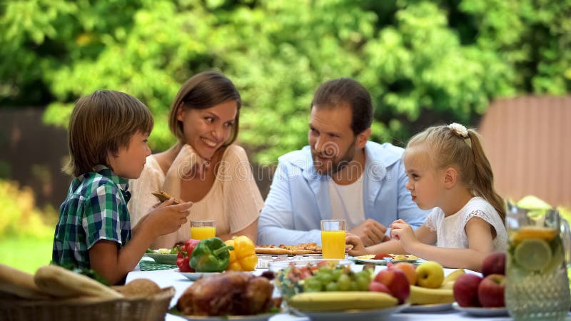 Friendly family having traditional dinner outdoors, parents kids happy together stock image Friendly family having traditional dinner outdoors, parents kids happy together stock image