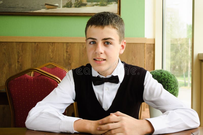 Friendly teenager boy waiting for friends in caffe