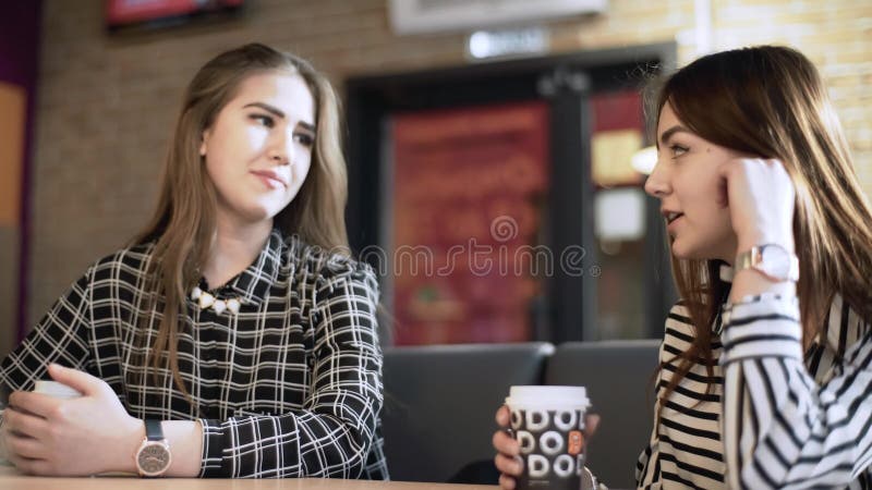 Friends in a cafe bar. Girls drink coffee in a cafe. girlfriends are sitting at a table in a cafe.