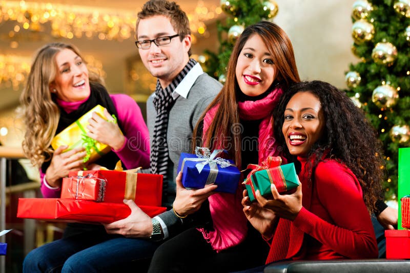 Friends Christmas shopping with presents in mall