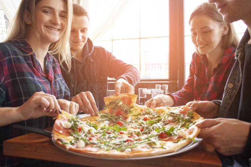 Friends Of Classmates Eat Pizza In A Pizzeria, Students At Lunch Eat