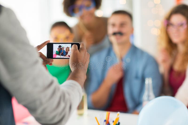 Friends or coworkers photographing at office party stock images Friends or coworkers photographing at office party stock images