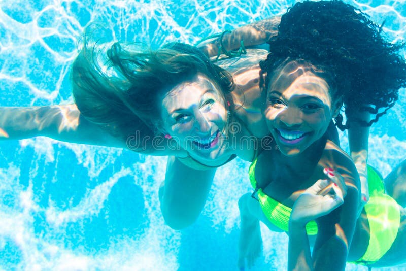 Friends diving underwater in swimming pool royalty free stock photo
