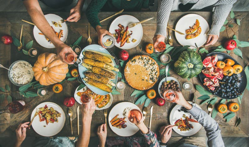 Friends eating and feasting at Thanksgiving Day with vegetarian meals