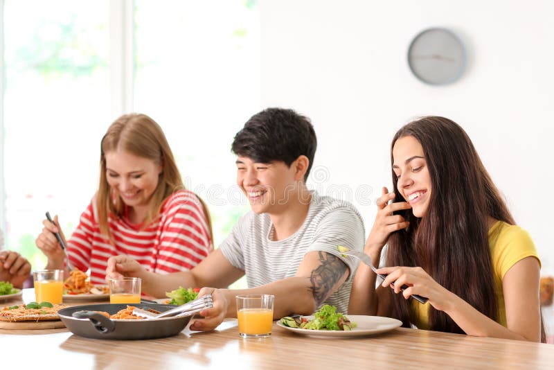 Friends Eating at Table in Kitchen Stock Photo Image of food, female
