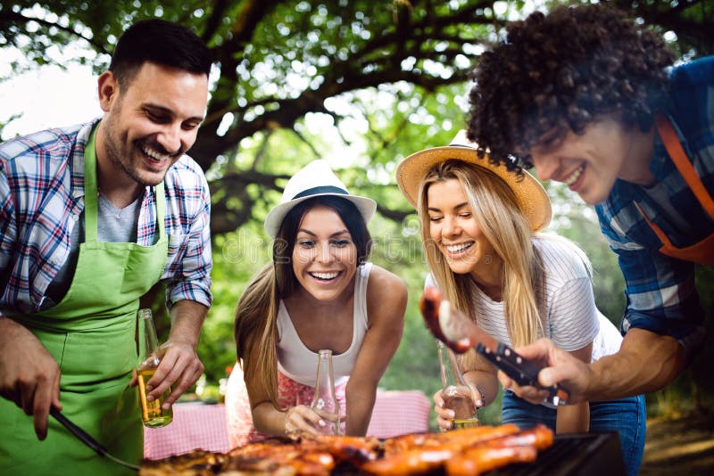 Friends Having a Barbecue Party and Fun in Nature Stock Photo Image