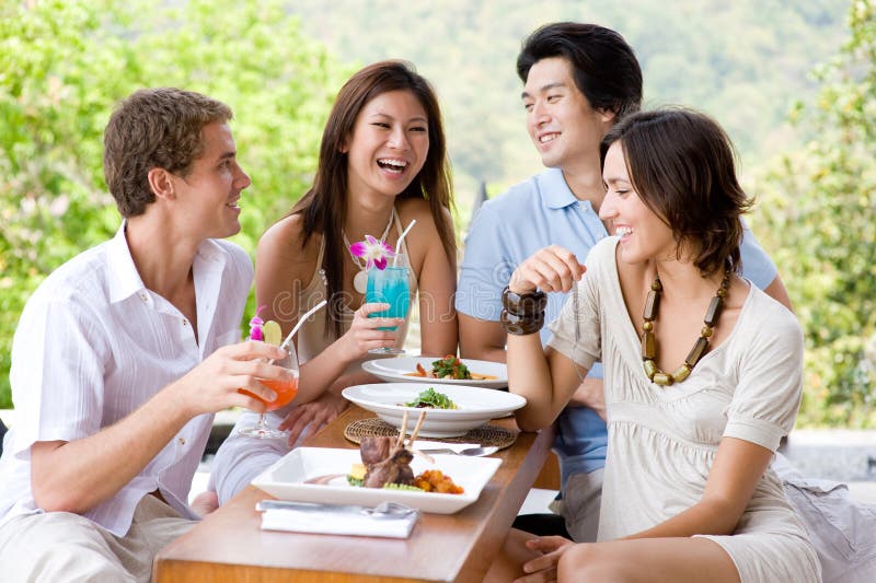 Cuatro adultos jovenes feliz comida común sobre el día festivo.