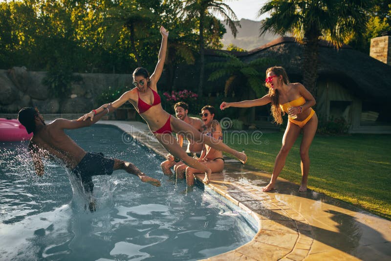 Friends having summer vacation party at the poolside