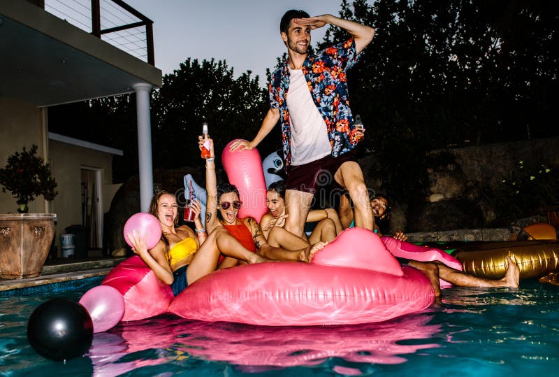 Friends partying in a pool in evening