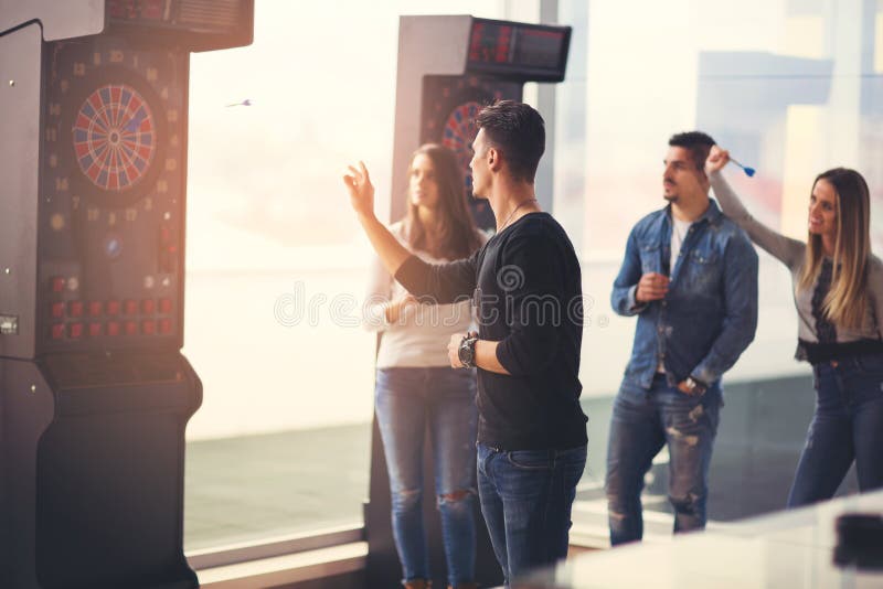 Friends playing darts in a club stock images