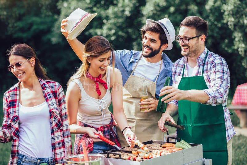 Onvermijdelijk binnen plank Friends Stand at a Barbecue, One Cooking at Grill Stock Photo - Image of  barbeque, eating: 168654284