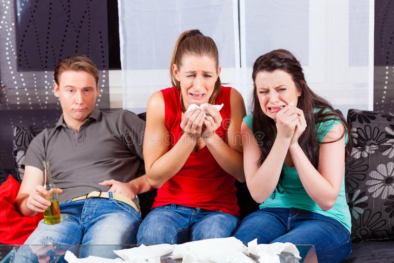 Friends watching a sad movie in TV royalty free stock photography Friends watching a sad movie in TV royalty free stock photography