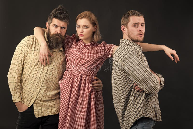 Friendship. Love triangle concept. Men, woman on pensive faces, black background. Men in checkered clothes, retro style royalty free stock image Friendship. Love triangle concept. Men, woman on pensive faces, black background. Men in checkered clothes, retro style royalty free stock image