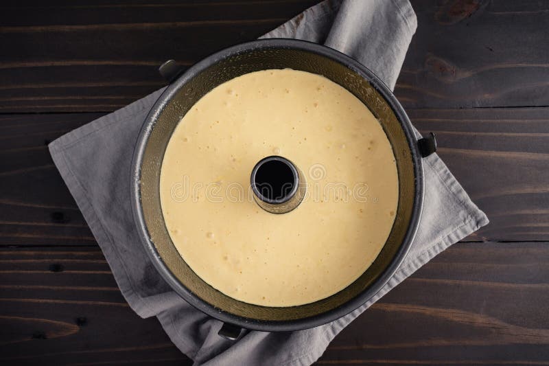 A non-stick angel food cake pan filled with yellow cake batter viewed from directly above. A non-stick angel food cake pan filled with yellow cake batter viewed from directly above