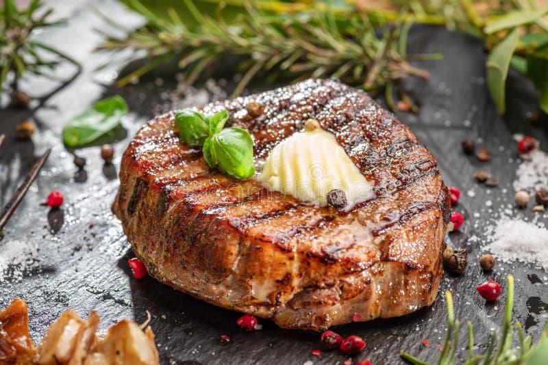 Friptură delicioasă de sfeclă la grătar cu bucată de unt pe ea. Friptura este pe tabla neagră de servire. Plat lay royalty free stock photos