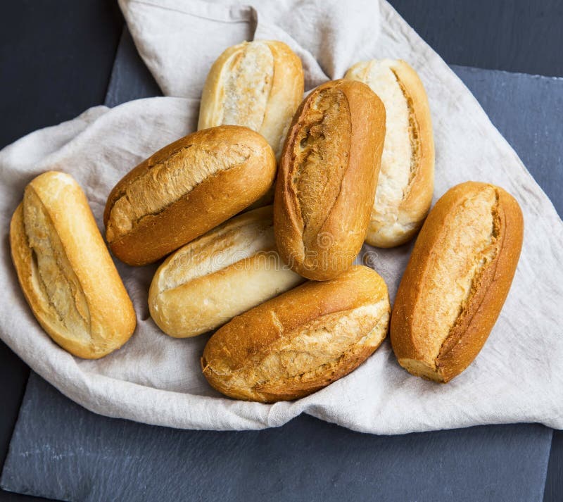 Frisch gebackene Brotbrötchen auf einem Leinentuch, Brötchen des ganzen Brotes häufen stockfotografie