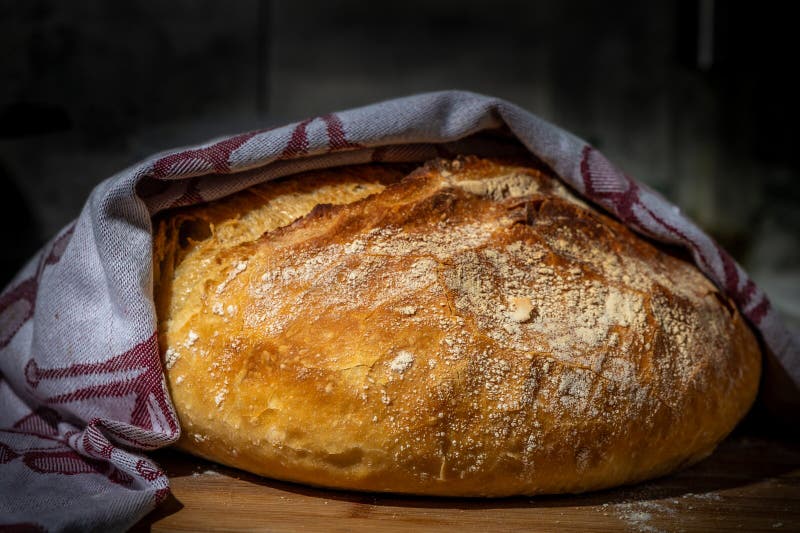Frisch gemachtes Vollweizenbrot, grauer Hintergrund 1. Frisch gebackenes knuspriges Brot