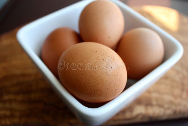 Frische braune Eier in einer quadratischen Schüssel stockbild Frische braune Eier in einer quadratischen Schüssel stockbild
