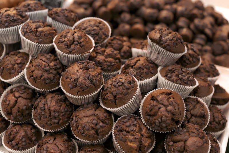 Frische geschmackvolle Muffins auf Anzeige in der Bäckerei stockbild Frische geschmackvolle Muffins auf Anzeige in der Bäckerei stockbild