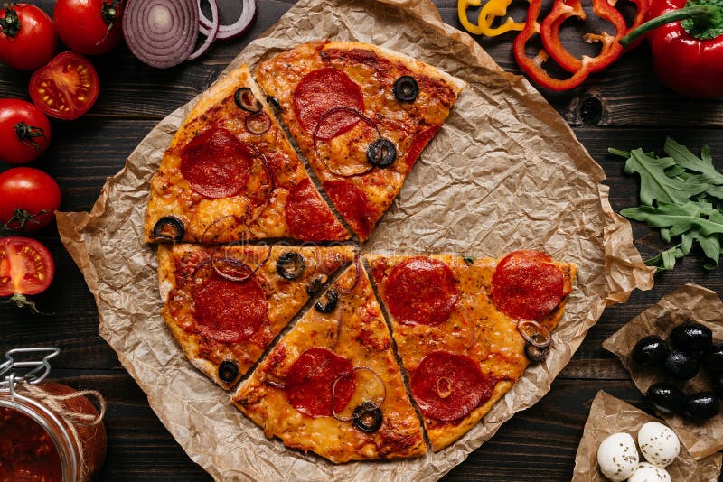 Frische köstliche Pizza mit Pizzabestandteilen auf dem Holztisch, Draufsicht lizenzfreies stockbild Frische köstliche Pizza mit Pizzabestandteilen auf dem Holztisch, Draufsicht lizenzfreies stockbild