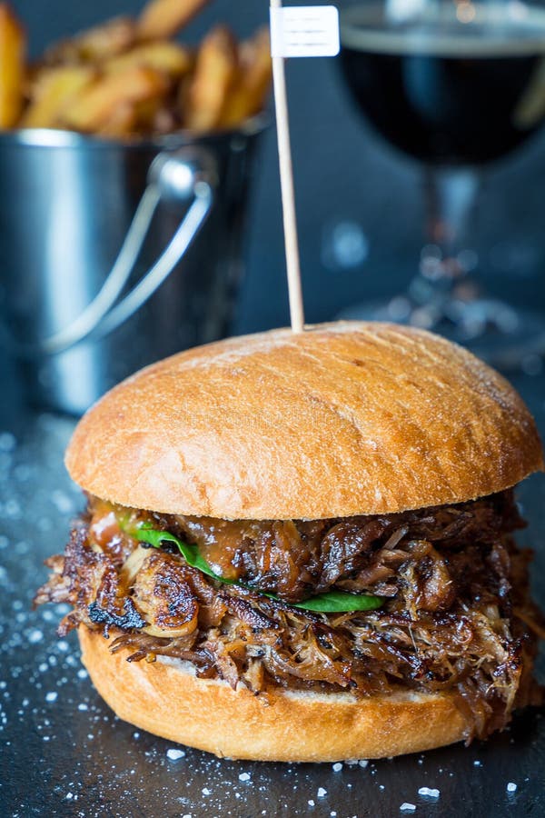 Frischer geschmackvoller großer Hühnerburger mit Käse, Soße und Fischrogen auf dunklem Steinhintergrund, Bier auf dem Hintergrund stockfotos Frischer geschmackvoller großer Hühnerburger mit Käse, Soße und Fischrogen auf dunklem Steinhintergrund, Bier auf dem Hintergrund stockfotos
