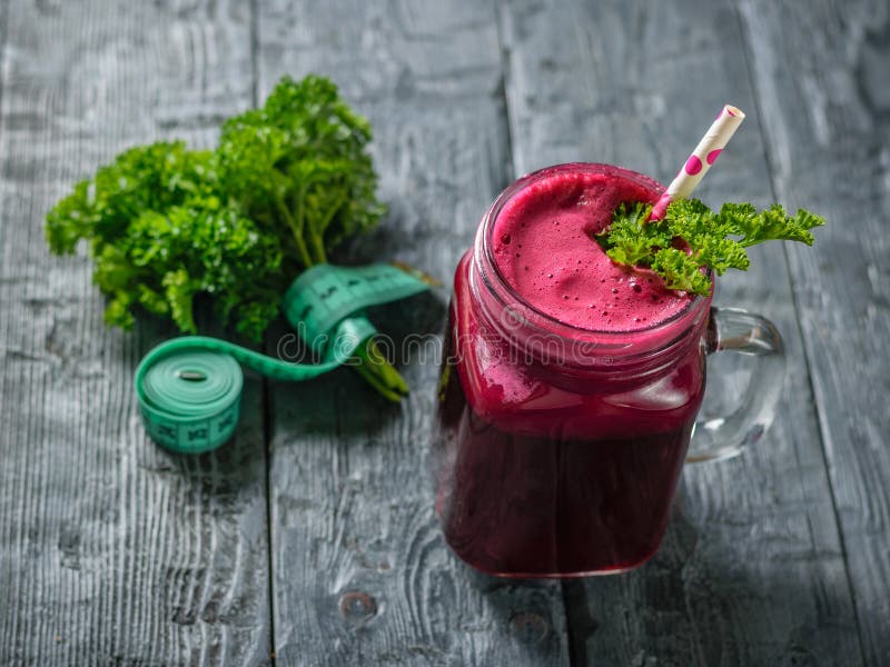 Frischer Rote-Bete-Wurzeln Smoothie, messendes Band und Petersilie auf schwarzem Holztisch Das Konzept der diätetischen Naturkost lizenzfreies stockfoto Frischer Rote-Bete-Wurzeln Smoothie, messendes Band und Petersilie auf schwarzem Holztisch Das Konzept der diätetischen Naturkost lizenzfreies stockfoto