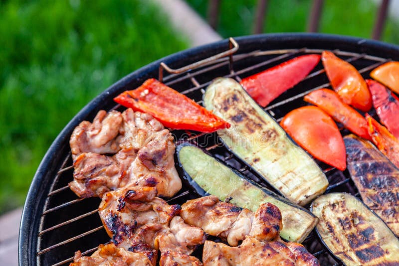 Frischfrisches, gesundes Gemüse, gegrilltes Hühnerfleisch auf dem Grillplatz über heißen Feuerkohlen gegen grünes Gras auf stockfoto Frischfrisches, gesundes Gemüse, gegrilltes Hühnerfleisch auf dem Grillplatz über heißen Feuerkohlen gegen grünes Gras auf stockfoto