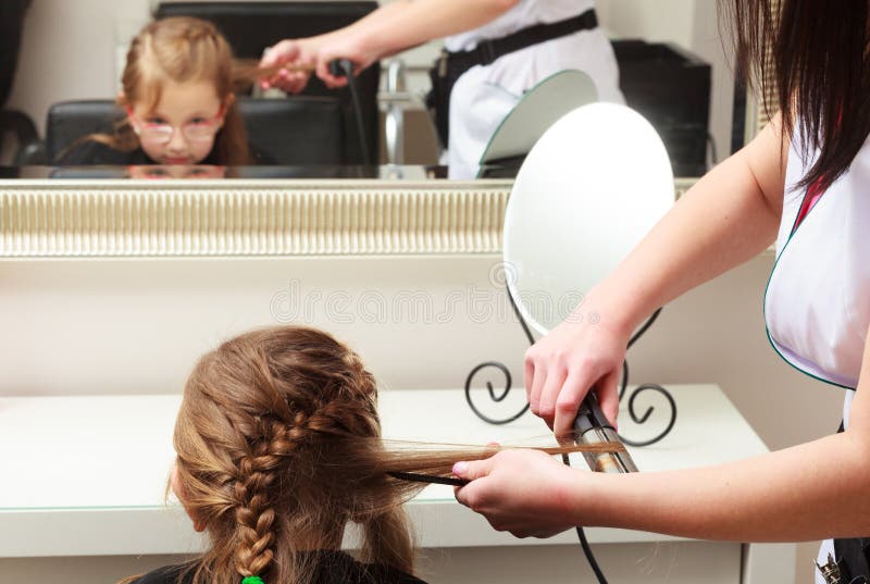 Friseur, der Kind des kleinen Mädchens des Haares im Frisurnschönheitssalon geraderichtet stockbilder Friseur, der Kind des kleinen Mädchens des Haares im Frisurnschönheitssalon geraderichtet stockbilder