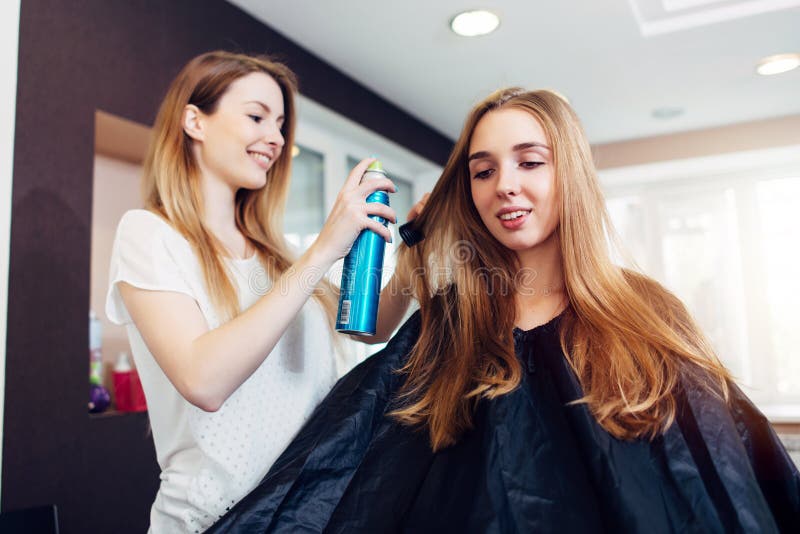 Friseurfestlegungsfrisur des lächelnden weiblichen Kunden mit Haarspray im Frisurnschönheitssalon stockbilder Friseurfestlegungsfrisur des lächelnden weiblichen Kunden mit Haarspray im Frisurnschönheitssalon stockbilder