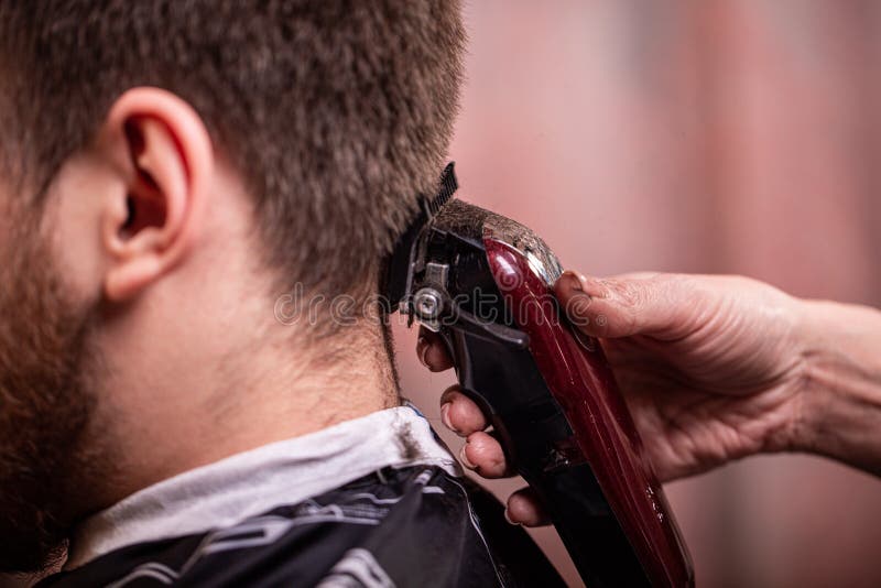 Frisyrcloseup Händer som rymmer en hårclipper Barberare stilskapelse, skönhet Sk?nhetsalong arkivfoto Frisyrcloseup Händer som rymmer en hårclipper Barberare stilskapelse, skönhet Sk?nhetsalong arkivfoto