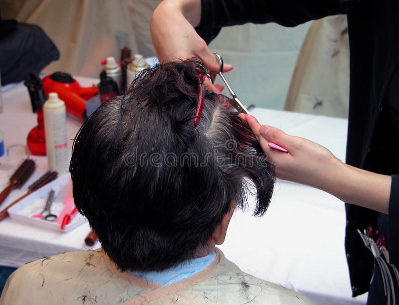 Two hand cutting hair in an old women had. Two hand cutting hair in an old women had.