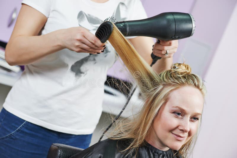 Frisör på arbete. Dryeing hår fotografering för bildbyråer