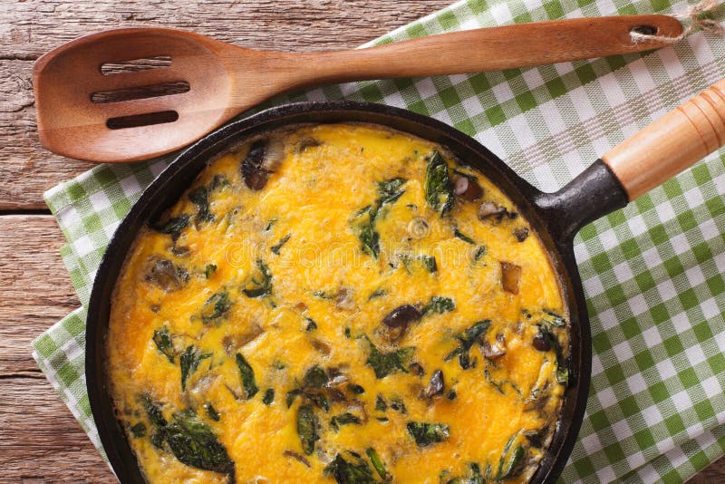 Fritatta with spinach, cheddar cheese and mushrooms in a frying