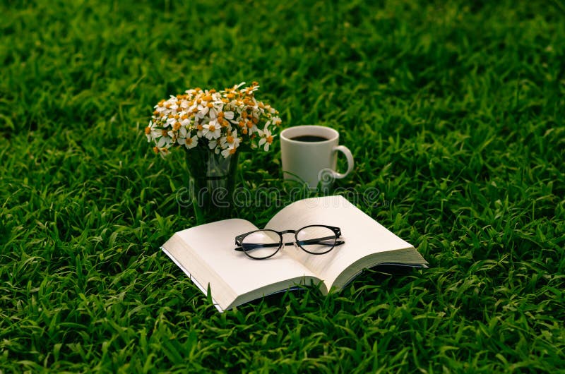 Leisure in morning at garden with coffee, book and flowers on the lawn. Leisure in morning at garden with coffee, book and flowers on the lawn