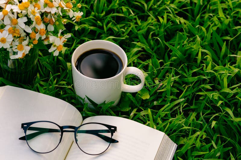 Leisure in morning at garden with coffee, book and flowers on the lawn. Leisure in morning at garden with coffee, book and flowers on the lawn