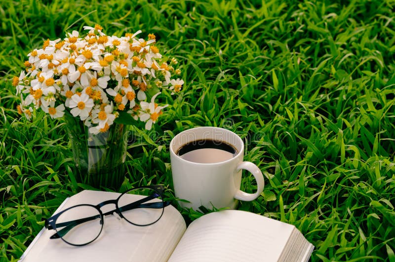 Leisure in morning at garden with coffee, book and flowers on the lawn. Leisure in morning at garden with coffee, book and flowers on the lawn