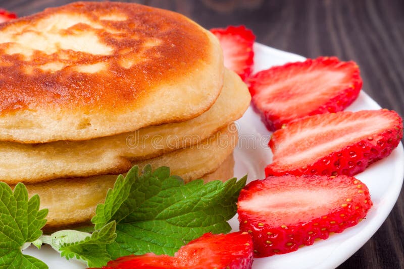Fritos em uma placa com fundo de madeira das morangos fotografia de stock
