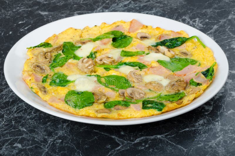 Frittata met ham, paddestoelen en spinazie royalty-vrije stock fotografie Frittata met ham, paddestoelen en spinazie royalty-vrije stock fotografie