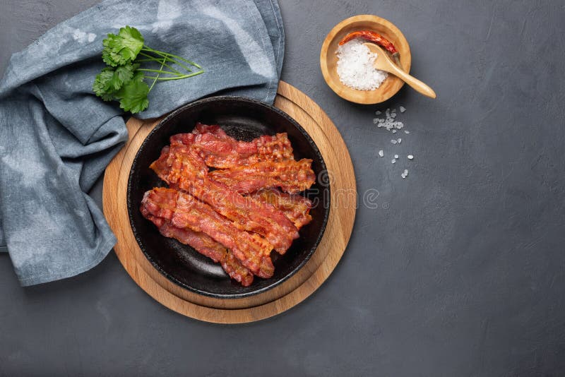 Frittierter Speck in einer gusseisernen Pfanne lizenzfreie stockfotografie