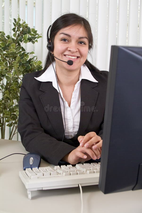 A young woman with a charming smile, working the helpdesk. A young woman with a charming smile, working the helpdesk.