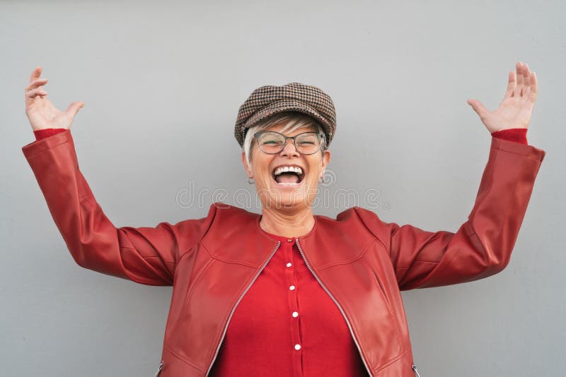 Frohe Installationsaufgaben Frauentanzen und lachen im Freien- modische reife Person, die Spaß im Laufe der Zeit der im Ruhestand lizenzfreies stockbild