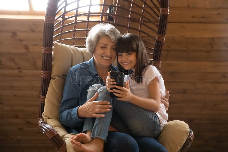 Frohe Installationsaufgaben Großmutter- und Enkelingebrauch Smartphonelachen