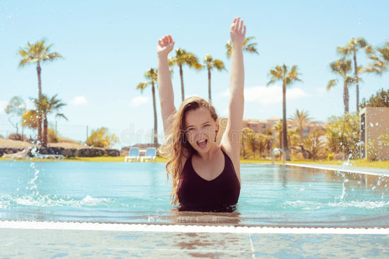 Happy girl in the pool, blonde with long hair in a red bathing suit. The girl rejoices in traveling, flirts, smiles, rejoices. Traveling. Girl on a background of palm trees. Happy girl in the pool, blonde with long hair in a red bathing suit. The girl rejoices in traveling, flirts, smiles, rejoices. Traveling. Girl on a background of palm trees