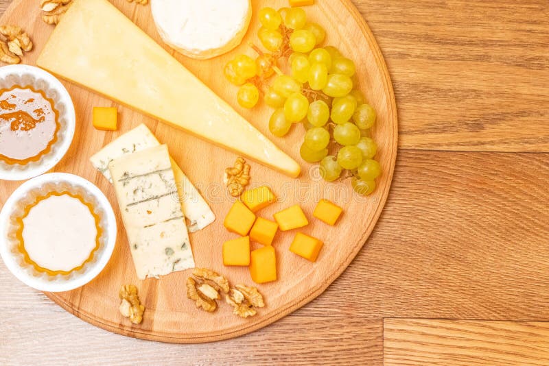 Fromages assortis de plat rond de conseil en bois photo stock Fromages assortis de plat rond de conseil en bois photo stock