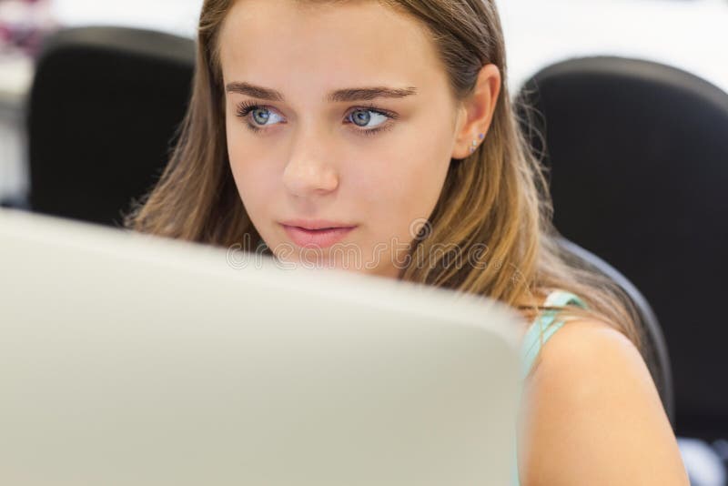 Fronsende mooie student die aan computer werken royalty-vrije stock foto's Fronsende mooie student die aan computer werken royalty-vrije stock foto's