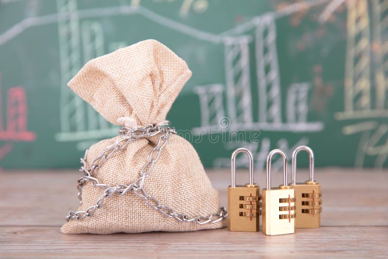 In Front of a Blackboard with Financial Charts, a Money Bag and a